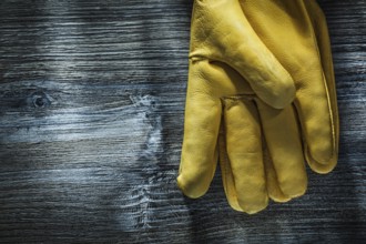 Pair of safety gloves on wooden board