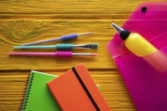 Back to school supplies arrangement vivid colorful neon color on yellow