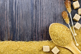 Sugar brown granules in a spoon, cubes and crystals on a stick in the form of a frame on the