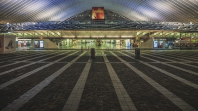 Architecture and entrance of a railway station at night, illuminated and symmetrical,