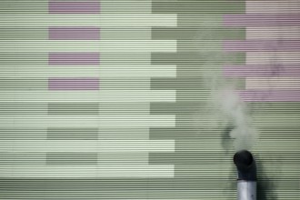 The smoking chimney of an industrial plant on the outer wall of a power station