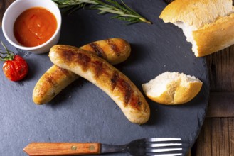 Rustic bratwurst with ketchup and fresh rolls