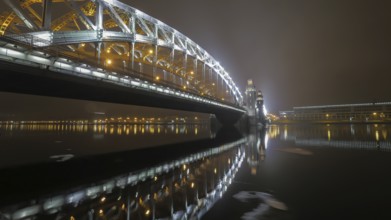 Illuminated Peter the Great Bridge across Neva River in night Saint Petersburg, Russia, Europe