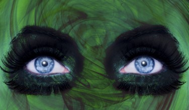 Abstract blue woman eyes makeup with a green texture skin