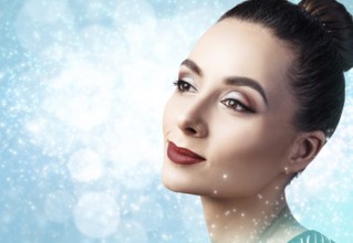 Portrait of young and beautiful woman with evening make-up over winter Christmas background