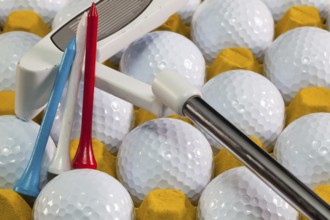 White golf balls in the yellow box and golf equipments