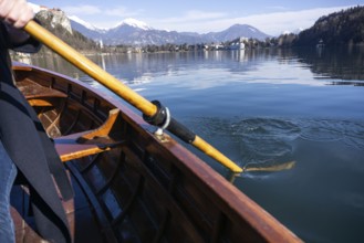 Young woman using paddle on a wooden boat, Lake Bled Slovenia rowing on wooden boats on a sunny day