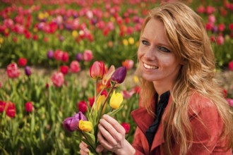 Portrait of a beautiful blond Dutch girl in tulips field