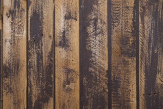 Unevenly painted dark wooden wall, uneven colour on the boards