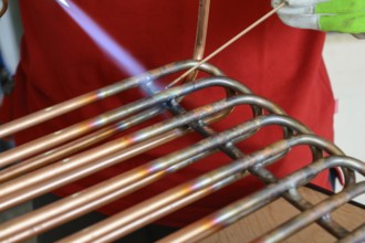 Skilled worker brazing copper - close-up