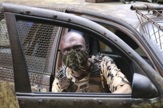 Man with mask in a post-apocalyptic car, ready for battle