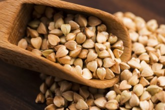 Buckwheat with a spoon on a wooden board background