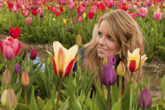 Portrait of a beautiful blond Dutch girl in tulips field
