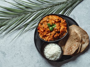 Indian cuisine dishes: tikka masala, rice, samosa, chapati, . Indian food on gray stone background