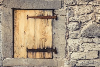Rustic architecture background with a stone wall of a german house, with it's wooden trap door and