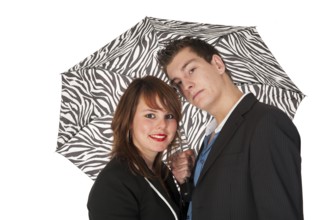 Young couple under black and white zebra umbrella