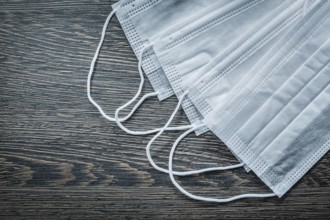 Disposable surgical masks on an old wooden board