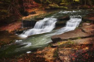 Stream with waterfall, water cascade in autumn scenery of the mountains