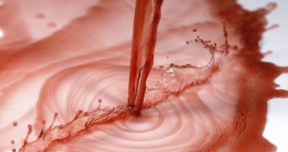 Red Wine being poured against White Background