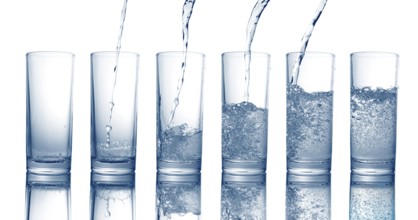 Pouring of fresh cool water in a glass isolated on white background