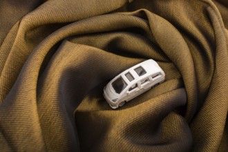 Miniature metal car on a brown fabric cloth