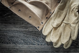 Protective gloves made of leather belt on black cardboard