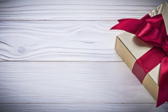Gift container with tied bow on wooden board holiday concept
