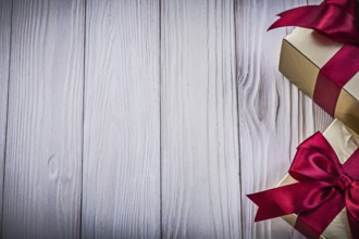 Gift boxes with tied red bows on wooden board copy space holiday concept