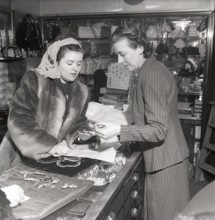 Shopping in the 1940s. A young woman in a store where a sales woman is presenting some of the
