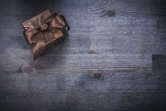 Packed gift box glittery paper on wood board holiday concept