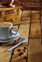 Close-up coffee cup and grinder on wooden table