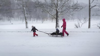 CHISINAU, MOLDOVA - JANUARY 29, 2021 Beautiful scene in the winter park with a mother and child