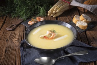 Delicious asparagus cream soup with prawns and fresh dill