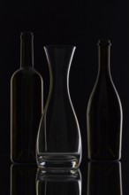 Empty glass and bottles on the black background