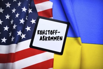 The flags of Ukraine and the USA with plaque and inscription Raw Materials Agreement, photomontage