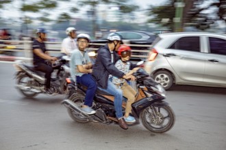 People riding motorbikes in city traffic, wearing helmets, blurred background, The crazy traffic of