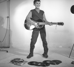 Boy in the 1950s. A boy is photographed in a studio and plays the guitar, perhaps with the Rock n'