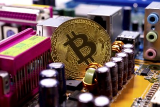 Virtual cryptocurrency money Bitcoin golden coin on a computer printed circuit board PCB. The