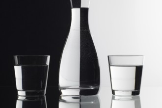 Glasses of water on the black and white background on the glass table