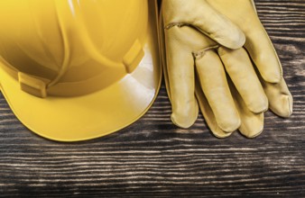 Safety gloves building helmet on wooden board construction concept