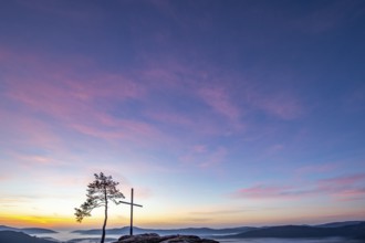 Summit cross on a sandstone rock in the middle of the forest. Landscape with a marvellous view over