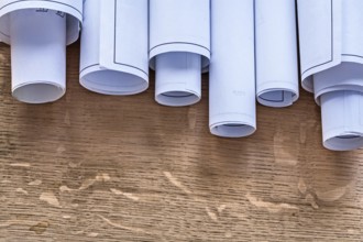 Pile of construction plans on wooden oaken board maintenance concept