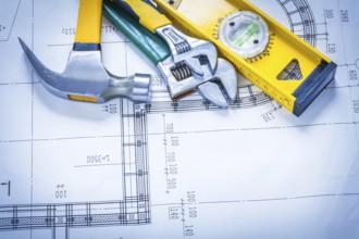 Claw hammer adjustable spanners construction level on blueprint maintenance concept