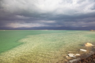Sunset. Incredible lighting effects in a thunderstorm at the Dead Sea. Multi-colored water in the