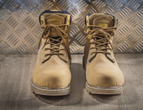 Safety waterproof lace shoes wooden board corrugated metal plate construction concept