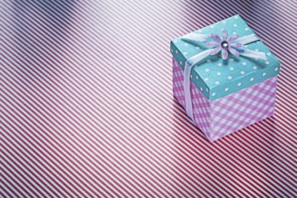 Present box on striped fabric background holidays concept