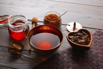 Bancha tea served in golden bowl on wooden table board