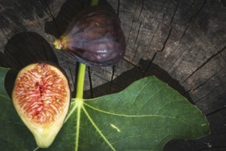 Figs and leaves on wood. Sun light