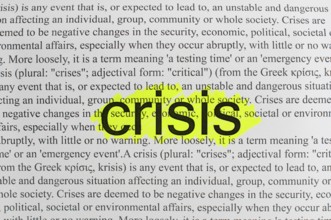Typed text Crisis on white paper.Yellow marked
