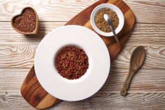 Red wild rice with sesame gomasio seasoning in a white plate over wooden board